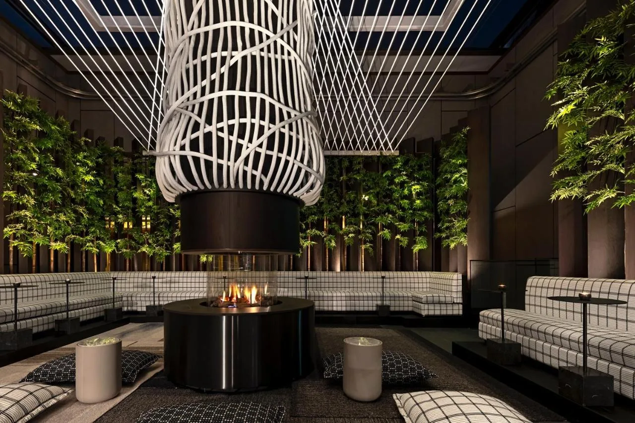 a rendering of a lobby with a fire pit at The Londoner in London
