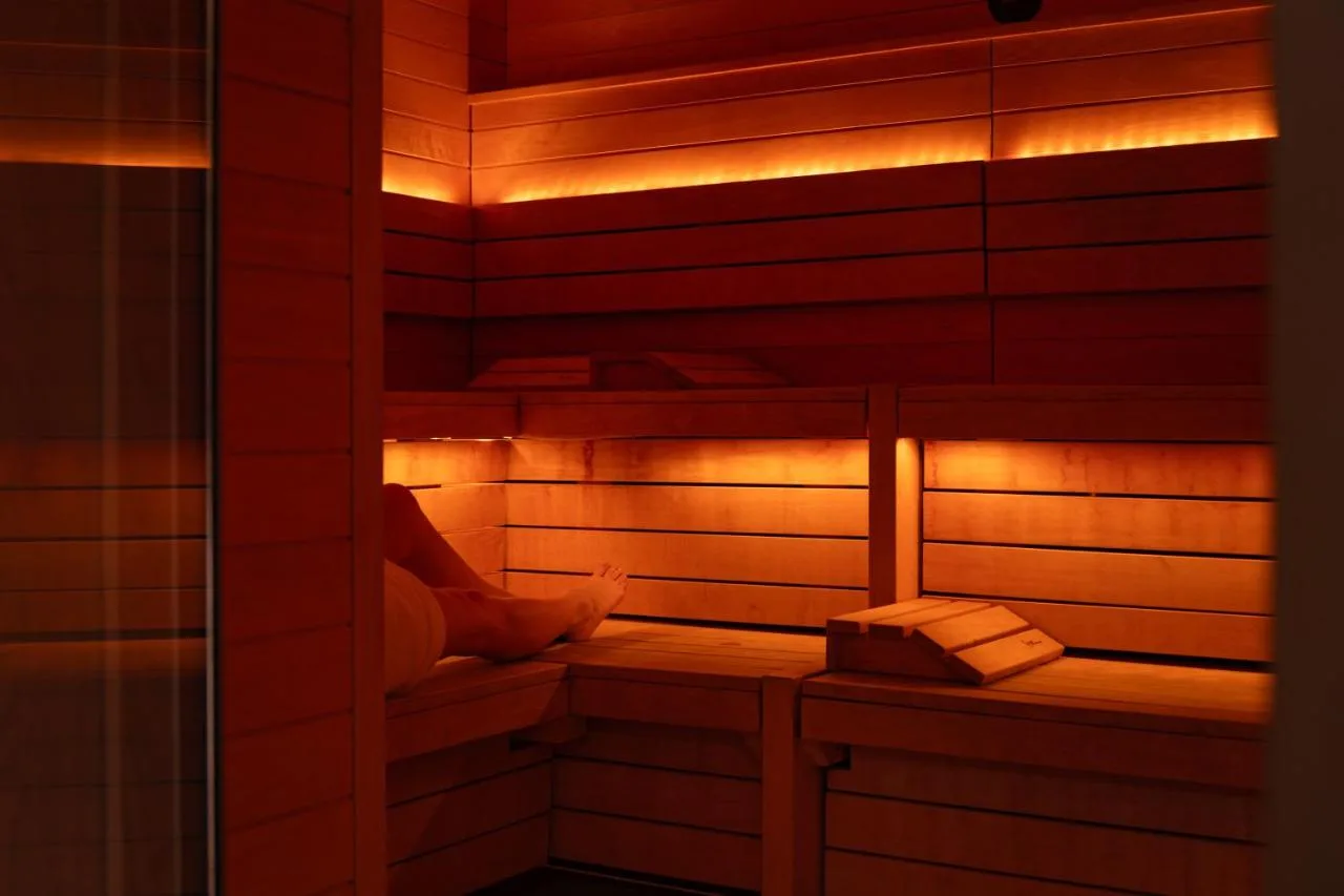 a person sitting in a sauna with lights at The Londoner in London